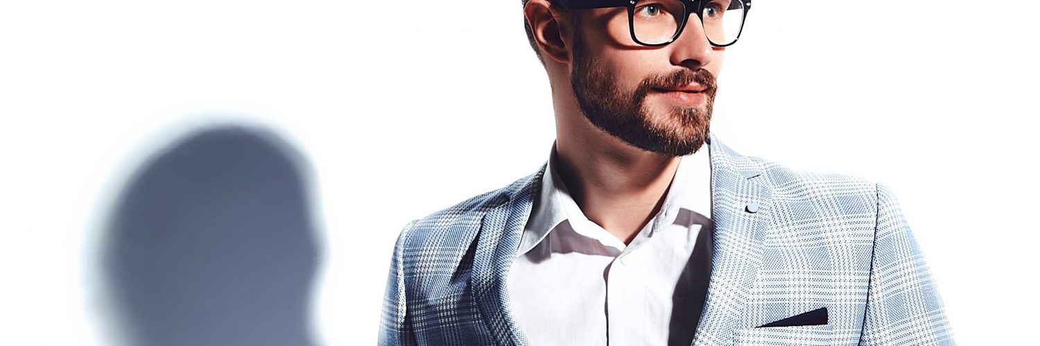 portrait of handsome fashion stylish hipster businessman model dressed in elegant light blue suit in glasses isolated on white